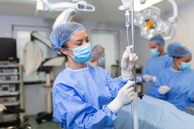 수술실에서 IV 수술 개념을 통해 약물을 투여하는 여성 의사