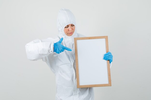 防護服の空白のフレームを指す女性医師