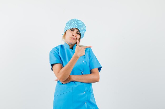 Female doctor pointing to the side in blue uniform