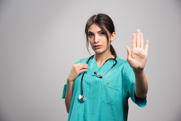 Female doctor posing on gray