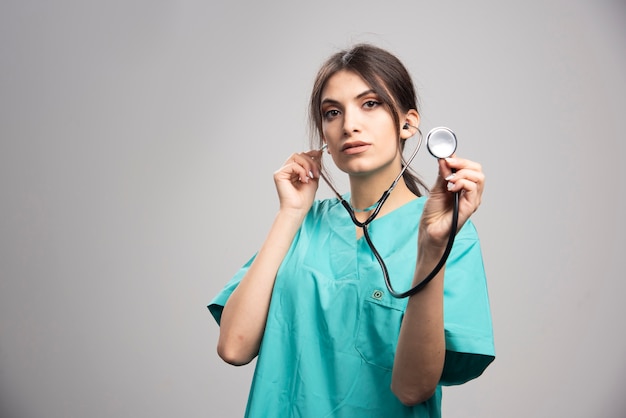 Medico femminile in posa sul grigio