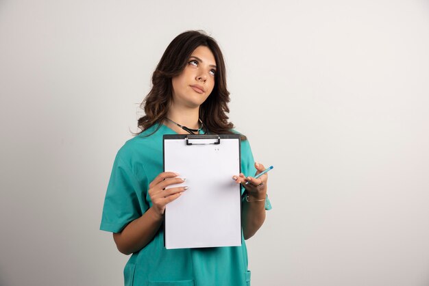 Female doctor posing with clipboard on white