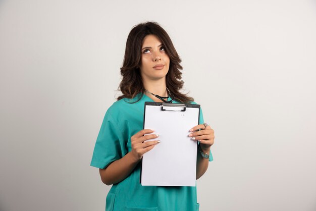 Female doctor posing with clipboard on white