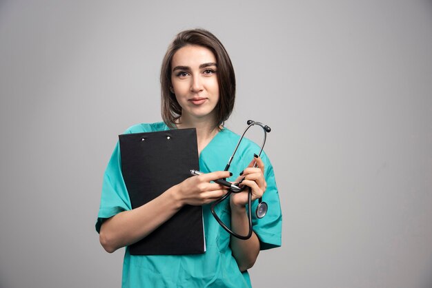 Female doctor posing with stethoscope and clipboard. High quality photo