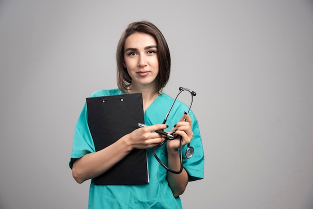 Female doctor posing with stethoscope and clipboard. High quality photo