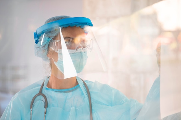 Female doctor in protective wear looking away