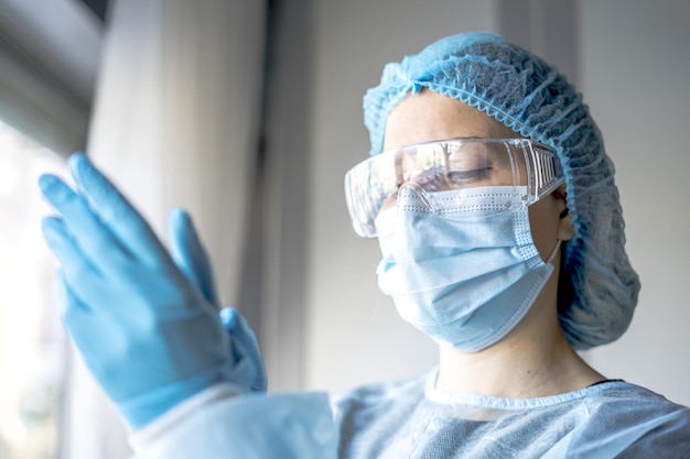 Free photo female doctor putting on protective blue gloves