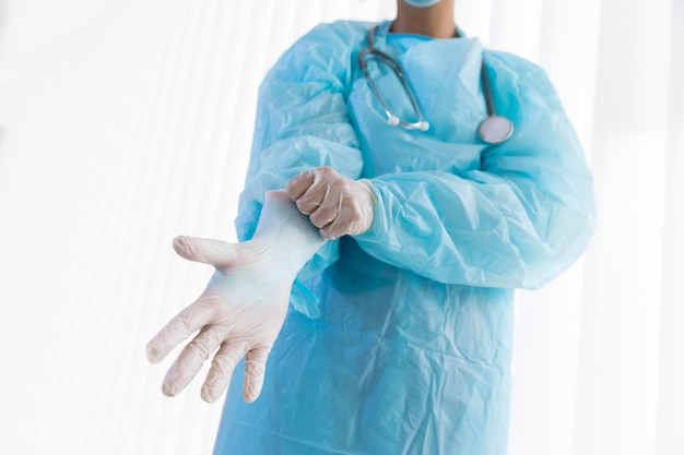 Female doctor putting on protective gloves