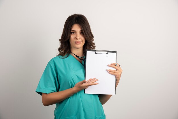 Female doctor showing documents on white