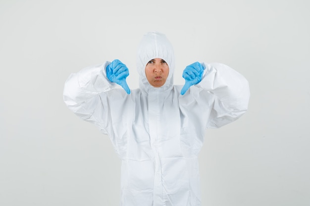 Foto gratuita medico femminile che mostra i doppi pollici giù in vestito protettivo