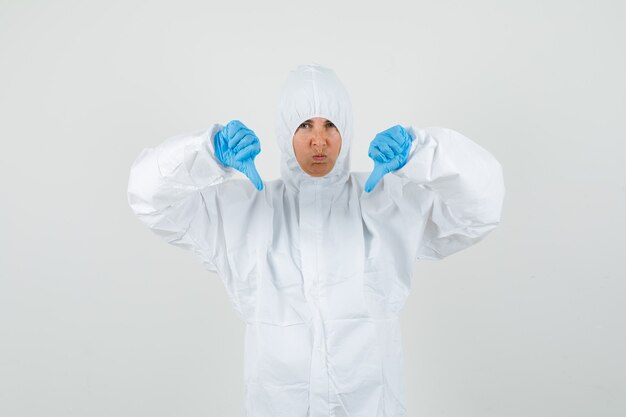 Female doctor showing double thumbs down in protective suit