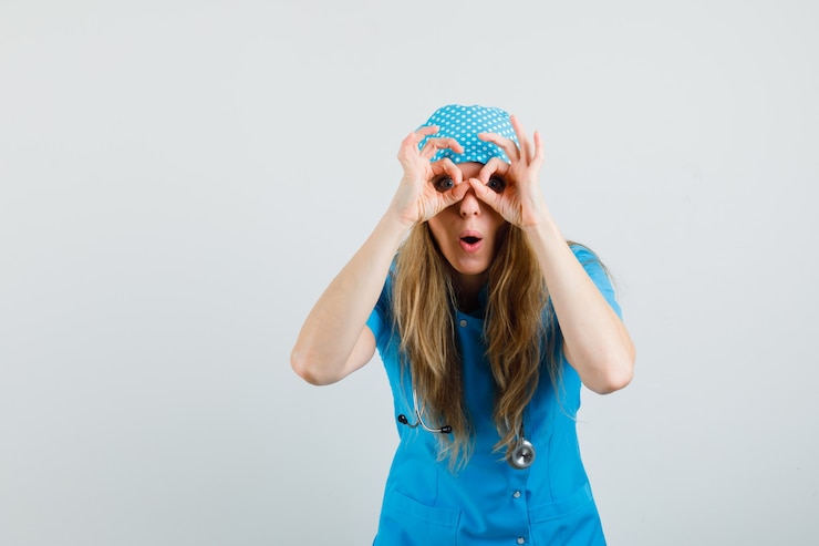 Free Photo female doctor showing glasses gesture in blue uniform and looking amazed 