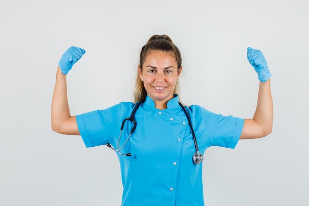 Female doctor showing muscles in blue uniform