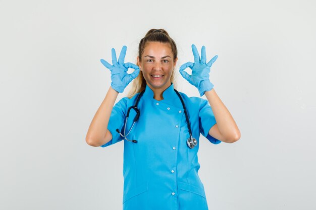 Female doctor showing ok gesture in blue uniform