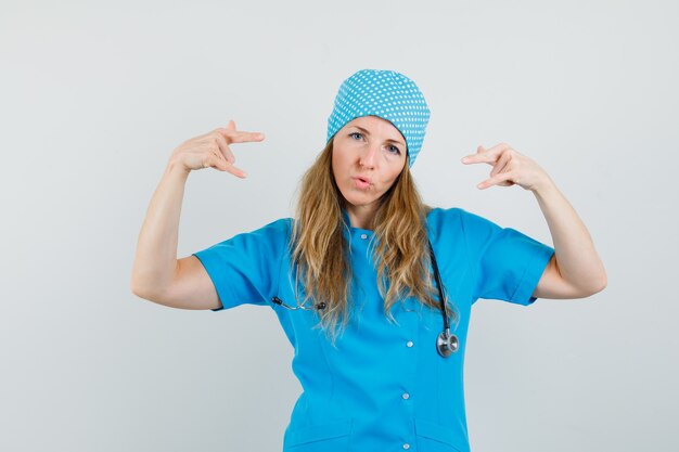 Female doctor showing rock sign in blue uniform and looking confident 