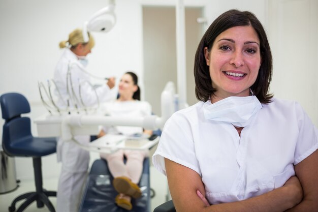 Female doctor standing with arms crossed at clinic