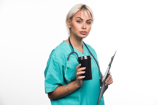 Female doctor taking a break with cup of coffee on white surface