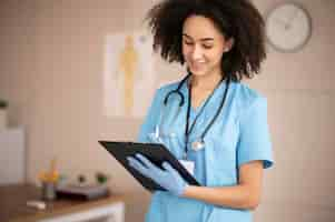 Free photo female doctor taking notes on a clipboard