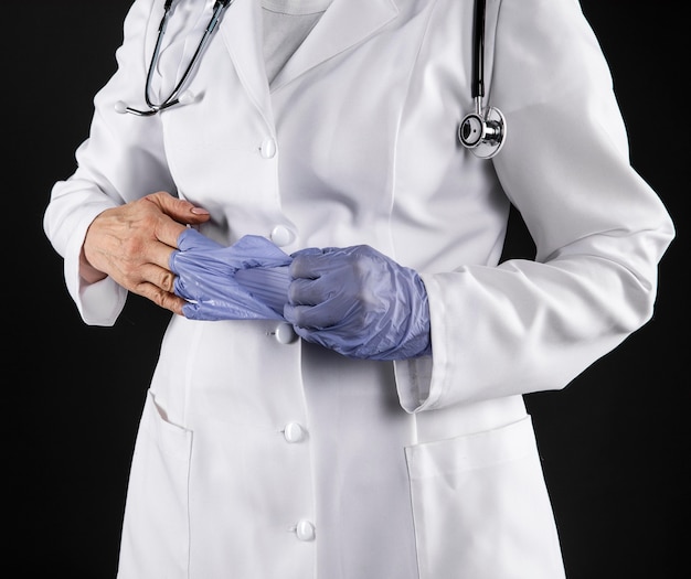 Женщина-врач, снимая перчатки