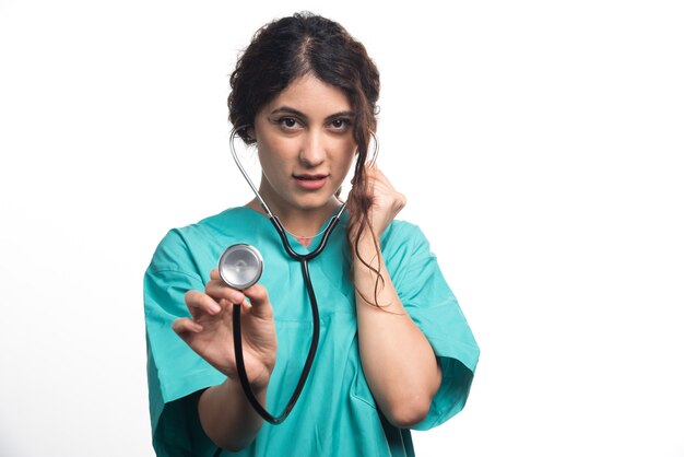 Женщина-врач с помощью стетоскопа на белом фоне. Фото высокого качества
