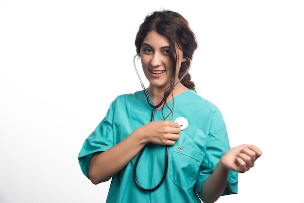 Женщина-врач с помощью стетоскопа на белом фоне. Фото высокого качества