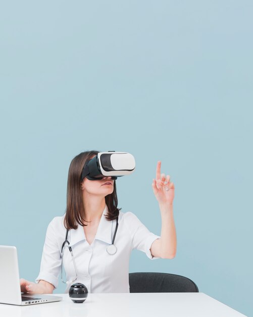 Female doctor using virtual reality headset with copy space