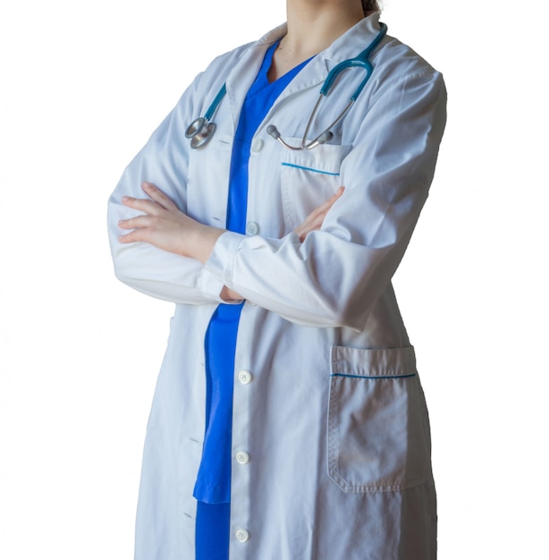 Foto gratuita medico femminile che indossa l'uniforme medica blu e un abito bianco che sta con confidenza con le mani attraversate