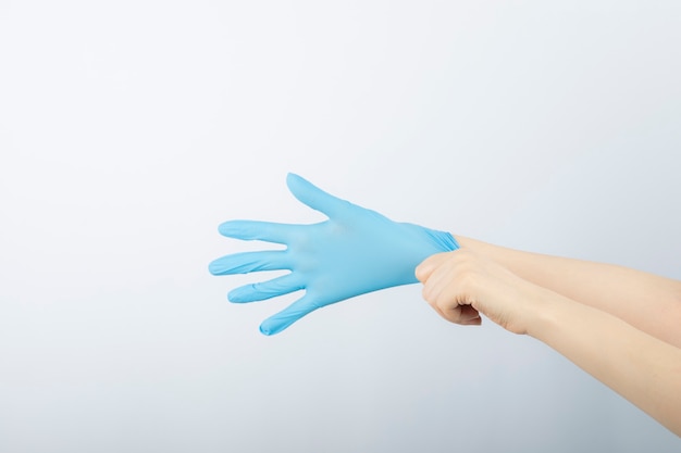 予防的流行コロナウイルスのために医療用手袋を着用している女性医師。