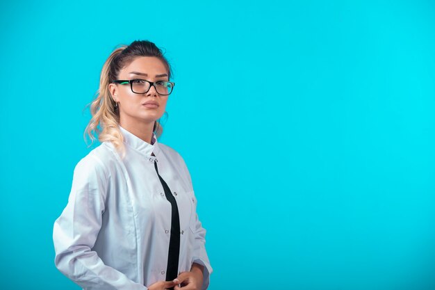 Female doctor in white uniform looks confident.