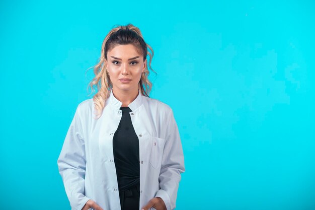 Female doctor in white uniform in professional posture.