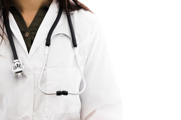 A female doctor with stethoscope around her neck against white backdrop