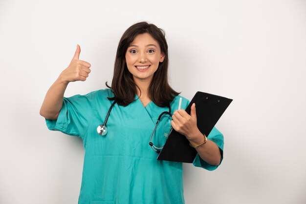 청진 기 및 클립 보드 흰색 바탕에 웃 고 여성 의사. 고품질 사진