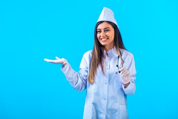 Female doctor with stethoscope introducing something.