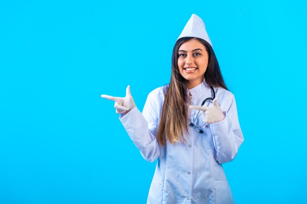 Female doctor with stethoscope pointing at something.