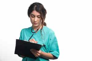 Free photo female doctor with stethoscope writes something in a clipboard on white background. high quality photo