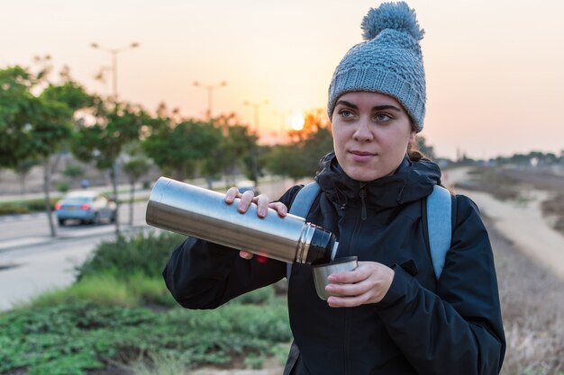 Female drinking hot coffee. Winter adventure. Wanderlust. Hiking and travel