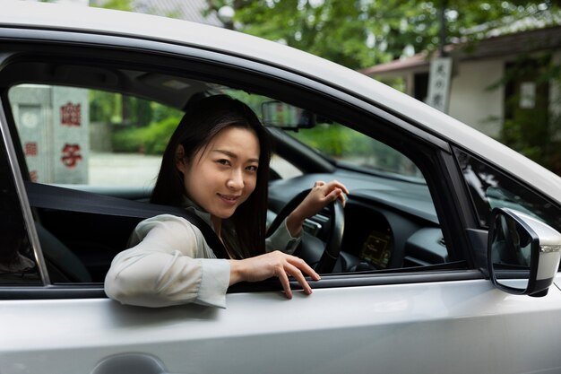 Female driver posing in an electric car