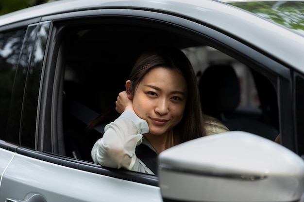 Female driver posing in an electric car