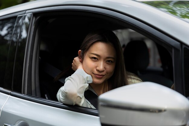 電気自動車でポーズをとる女性ドライバー