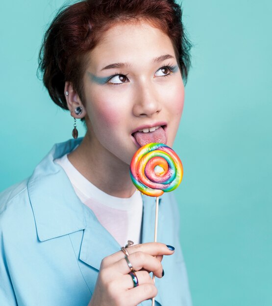 Female eating tasty multicolored lollipop