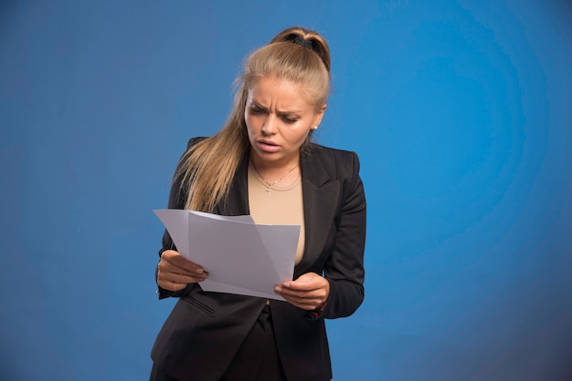 Female employee checking paper documents. 