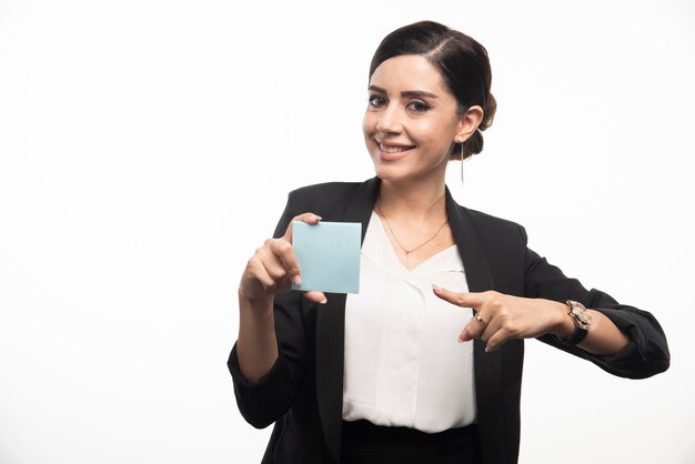 흰색 바탕에 메모 패드에서 가리키는 여성 직원. 고품질 사진
