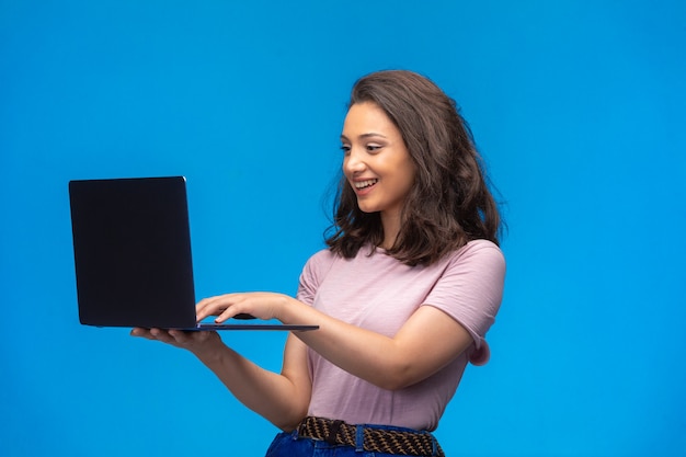 Female employee with a black laptop having video call and having fun.