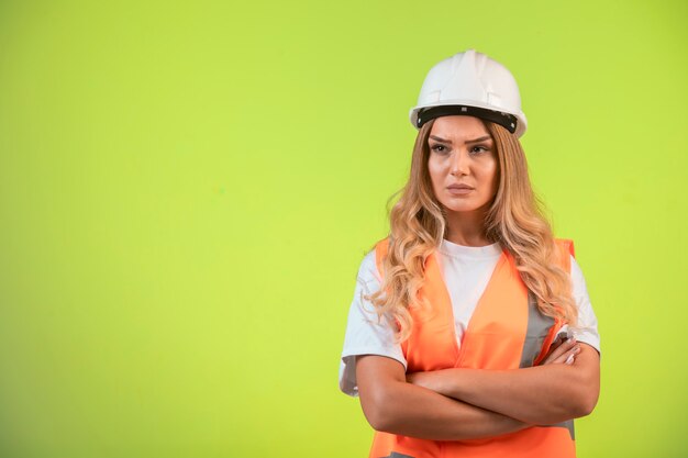 Female engineer in charge in white helmet and gear looks agressive.