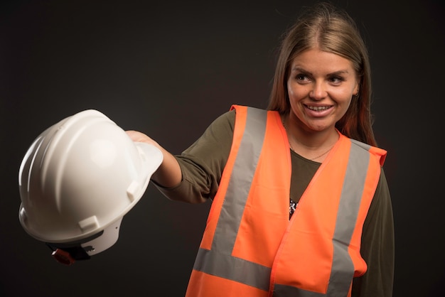 Foto gratuita ingegnere femminile che tiene un casco bianco e sembra positivo.