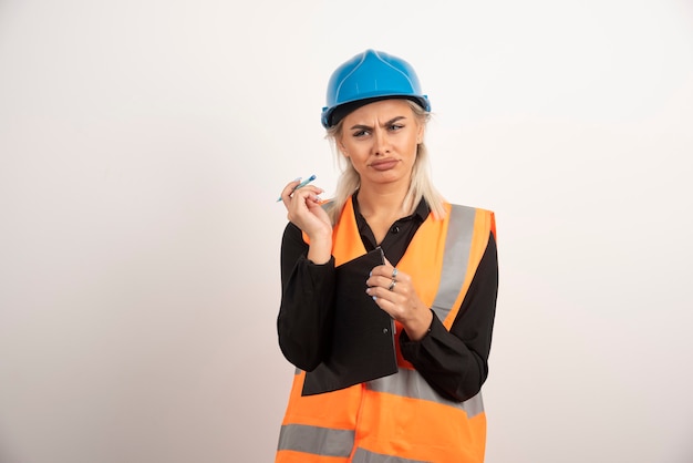 Женщина-инженер в униформе выглядит недовольной. Фото высокого качества