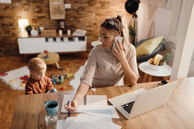 Free Photo female entrepreneur talking on the phone while being with her son at home