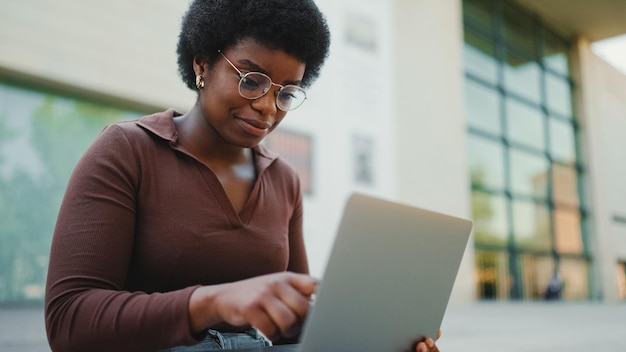 Female entrepreneur working on laptop outdoors African American