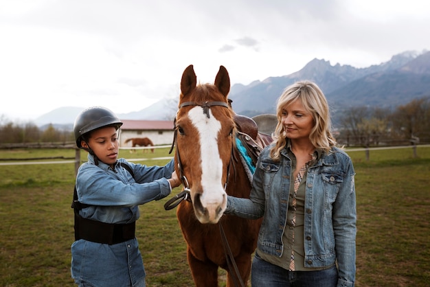 子供に馬の乗り方を教える女性馬術インストラクター