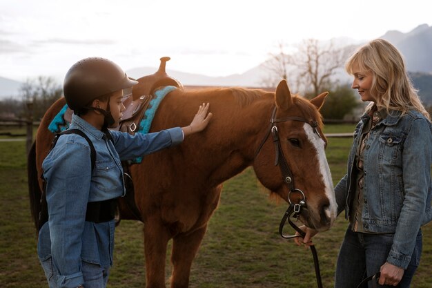 子供に馬の乗り方を教える女性馬術インストラクター